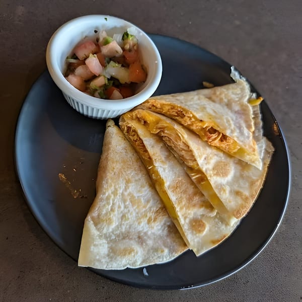 Aro Latin quesadillas with melted cheese and a side of fresh salsa on a dark plate.